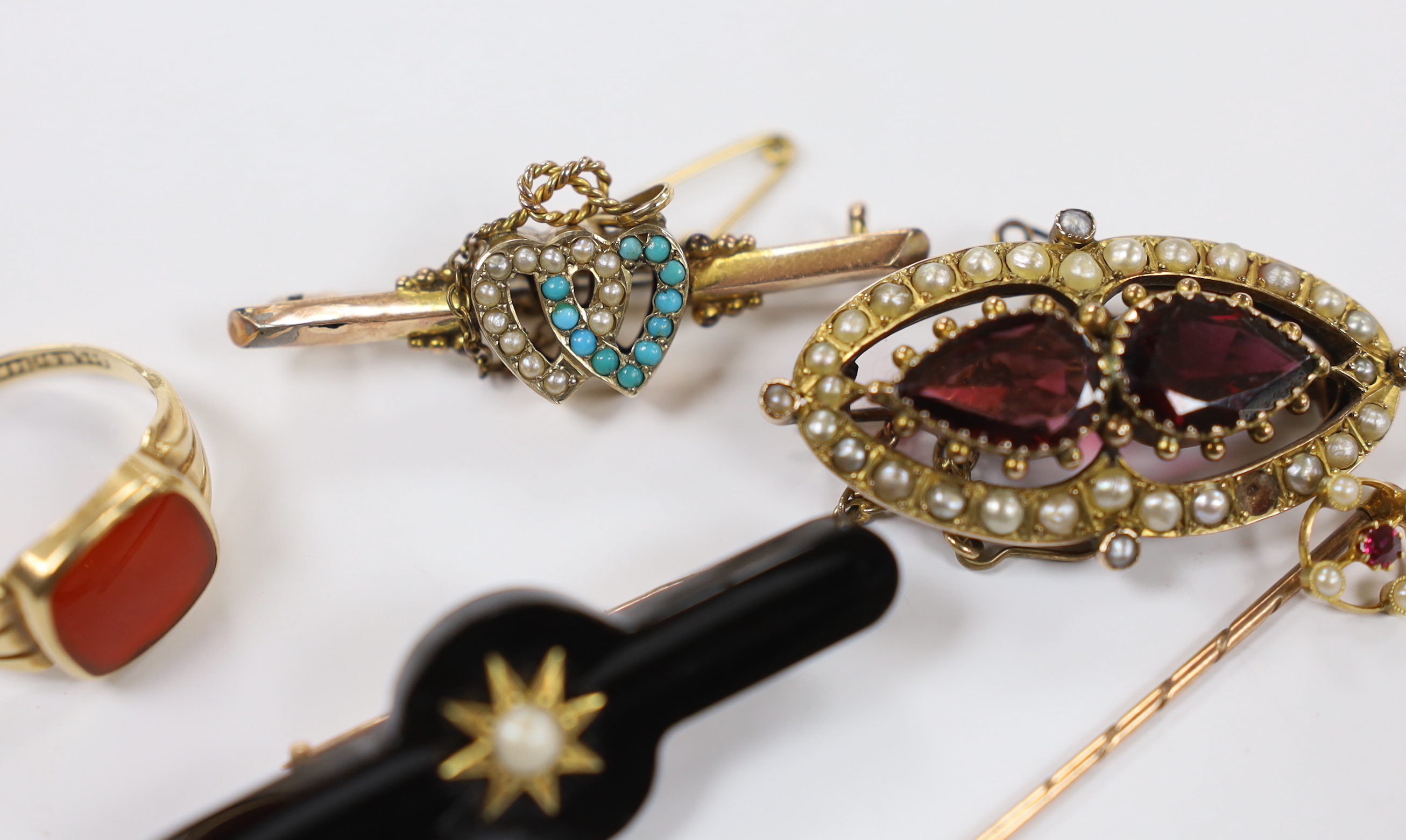 A 14k and carnelian set signet ring, size R/S, 3.1 grams, a Victorian yellow metal, two stone garnet and split pearl cluster set brooch, two other 9ct and gem set bar brooches including twin hearts and a 15ct and gem set